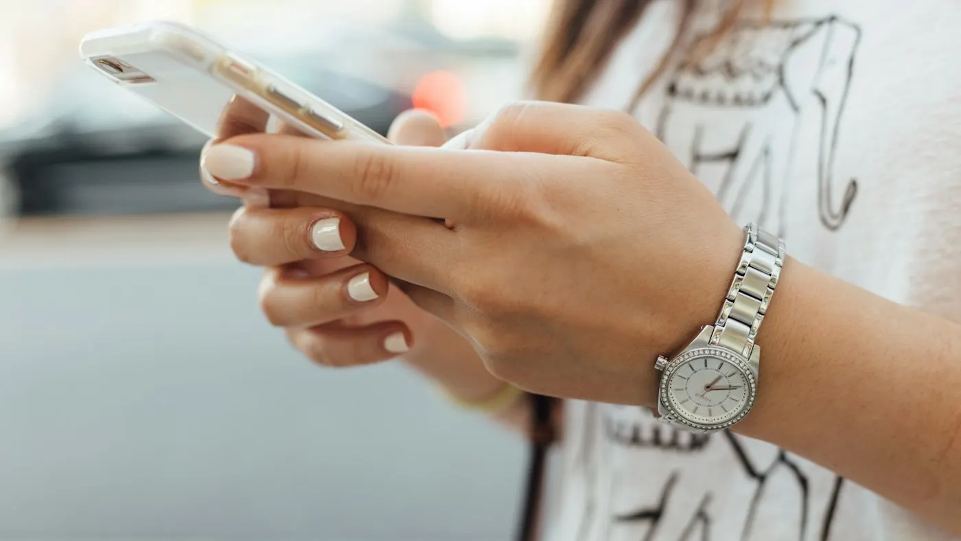Mãos de uma pessoa respondendo uma mensagem no celular